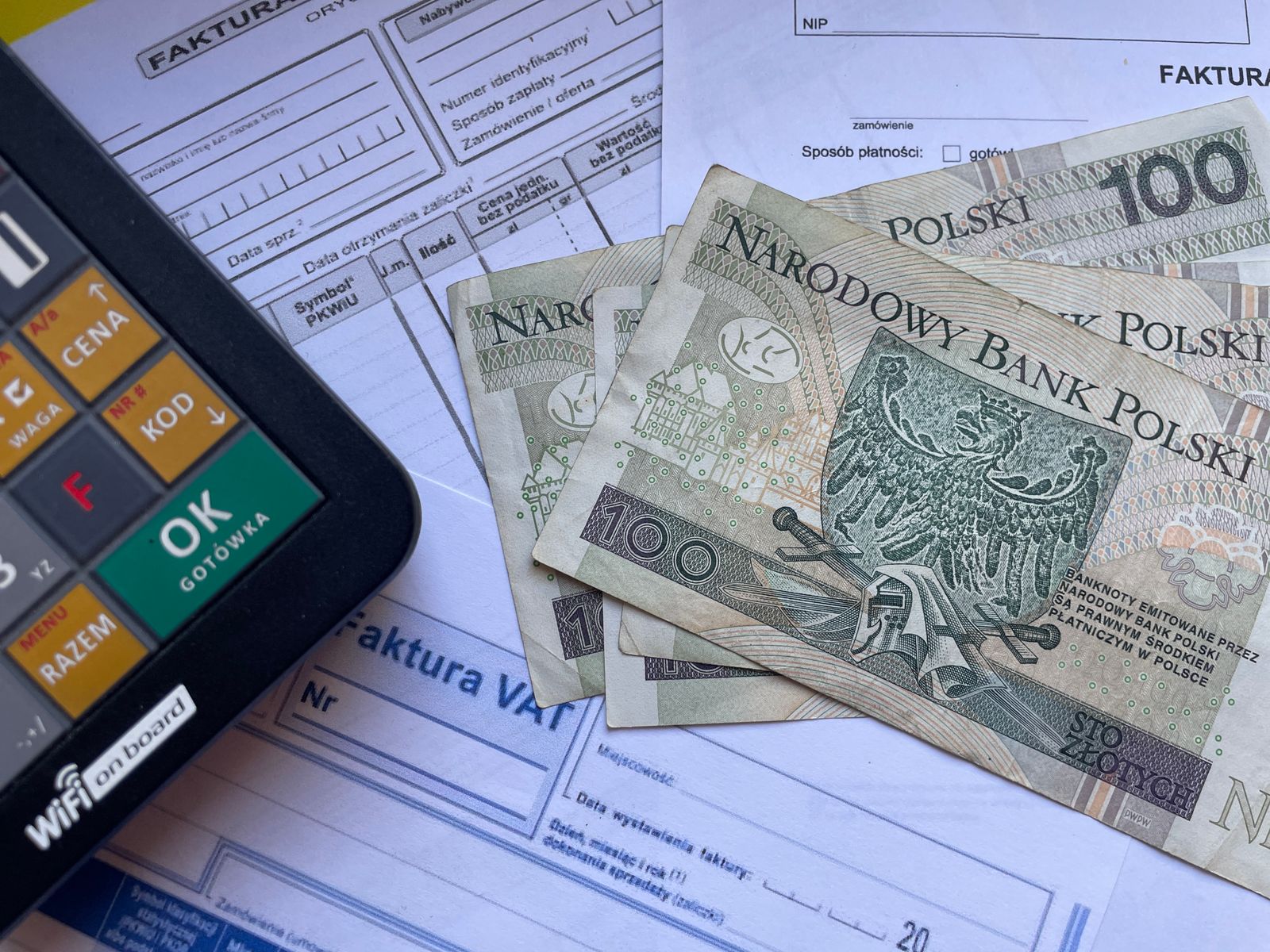 Overdue invoice with calculator and cash on a desk