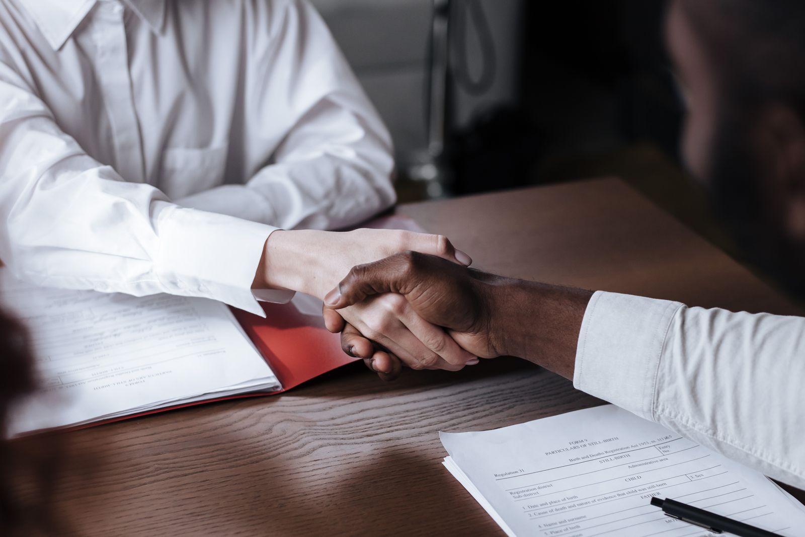Handshake over loan documents at a desk