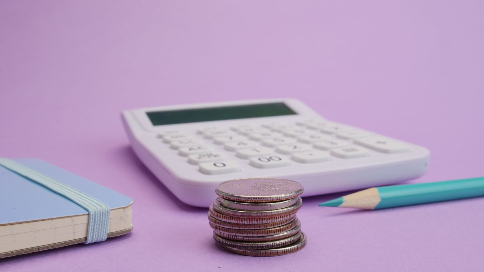 Calculator and stacked coins representing cost to collect